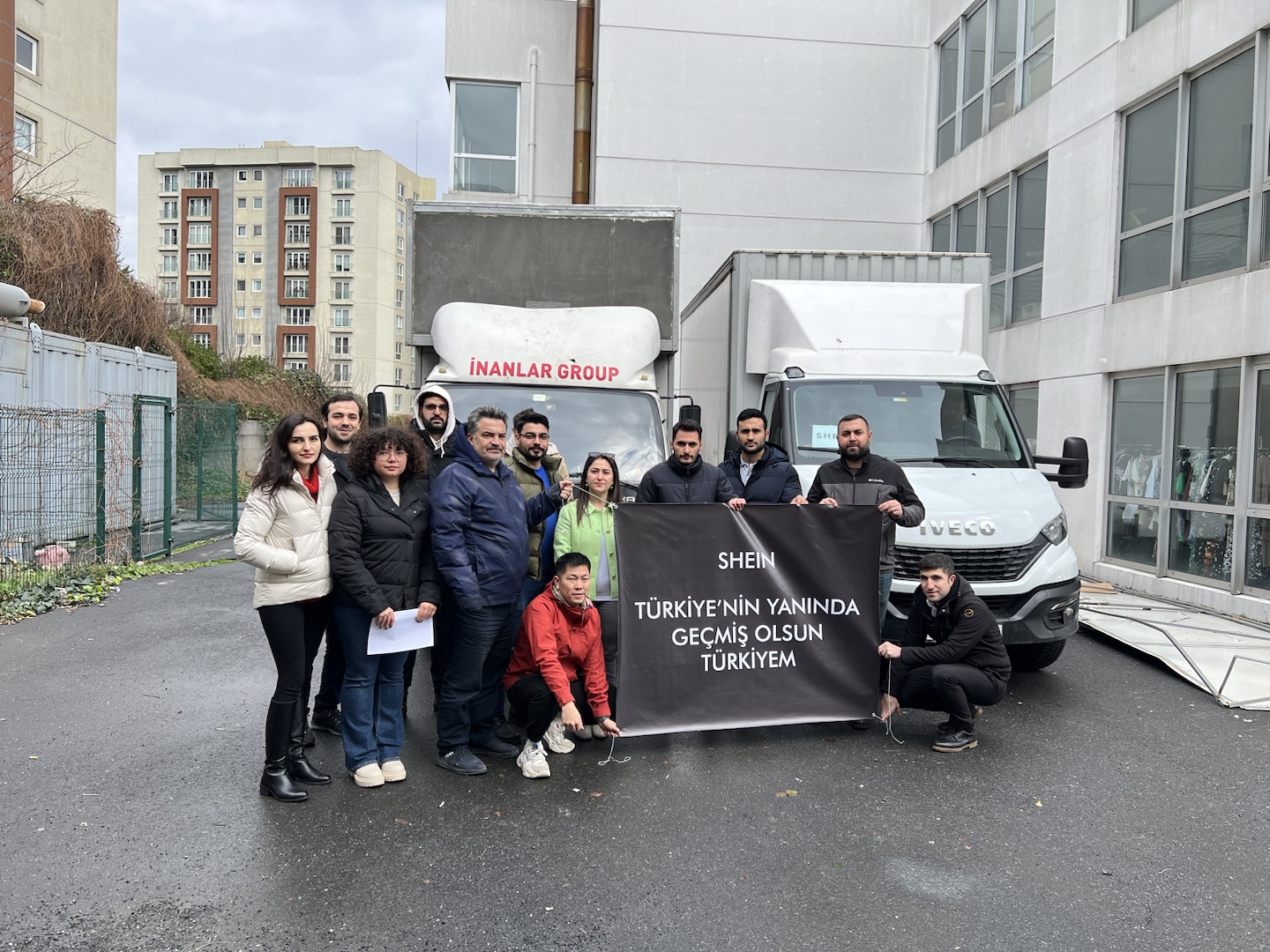 A photo of a group of people in Turkiye holding a banner with the shein logo